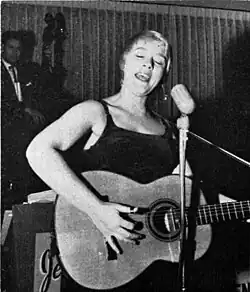 Black and white photograph of Barbara Dane singing and playing the acoustic guitar