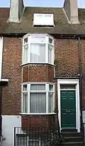 Brick coloured mathematical tiles on a bay window in George Street Location on Google Maps