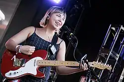 Lili Trifilio of Beach Bunny performing in 2022 with a red Telecaster guitar