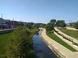 The Upper Bee Branch winding through an urban area with sidewalks along it.