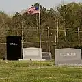 Looking east at multiple tombstones and a flagpole