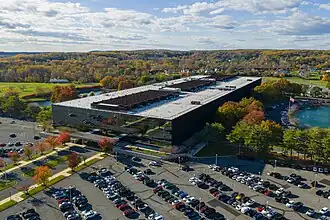 Aerial view of Bell Works, highlighting its long, mirror-like glass facade.