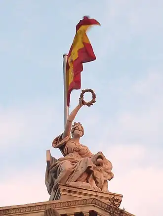 Finial figure of Spain with circular garland, atop the Biblioteca Nacional de España, Madrid, 1892–1903