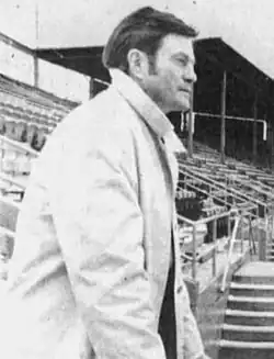 A black and white photograph of a man wearing a baseball uniform and cap with a "M".