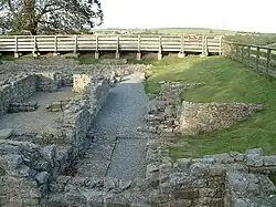The ruins of a building. The remains of stone walls up to about 1-foot (0.30&nbsp;m) are all that remains.