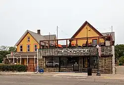 A photo of two former homes, now connected, and one has an addition on its front