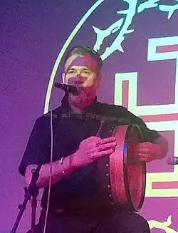 Moynihan singing while holding an instrument