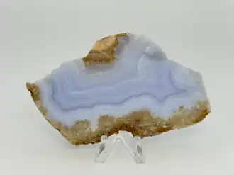 Unpolished slab of blue lace agate with green dolomite crystals (bottom)