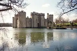 View of the castle in pale winter light framed by bare trees.