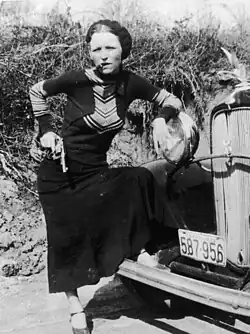 Parker's playful pose with a cigar brands her in the press as a "cigar-smoking gun moll" when police find the undeveloped film in the Joplin hideout