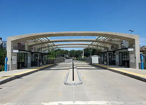 A bus station with an arched canopy over the platforms and bus lanes