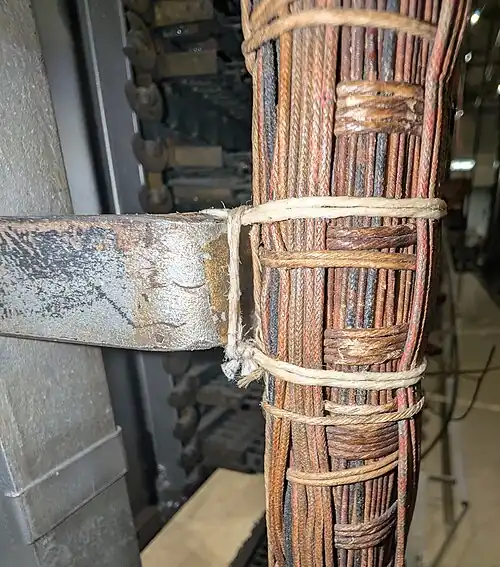 A box stitch used to secure a bundle of wires to a frame. The wires are bundled with a running stitch, and are secured to the frame with the box stitch.