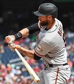Brandon Belt, mid swing in a gray uniform, in 2022