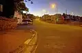 Bray Hill at dusk. The racing line is tight into the kerb, hence the scraping of the road surface created by the motorcycles' fairing belly pans as their suspension compresses.