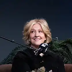 A photo of Brown at SXSW 2025. There is a microphone in front of Brown's face.