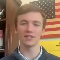Headshot of Hollyhand in front of an American flag