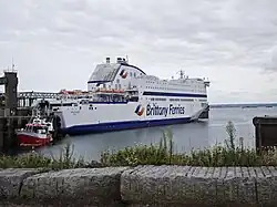 Large roll-on/roll-off ferry MV Armorique (Brittany Ferries) berthed at a port with a small service boat alongside.