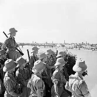 British soldiers in beige uniforms armed with a rifle.