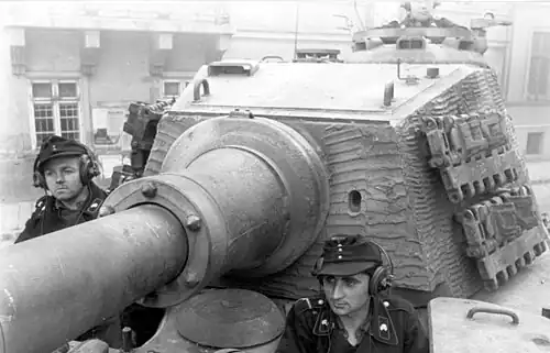 A tank turret with an almost square, flat, vertical face, the sides are almost vertical, and curve laterally only slightly.