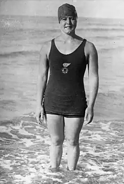 A woman wearing a tank top and pants