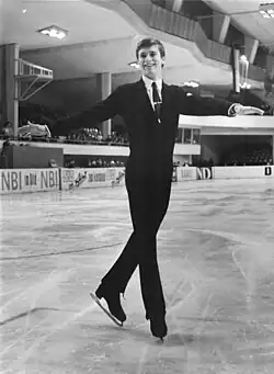 An image of Günter Zöller smiling and skating with his hands extended and feet crossed