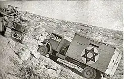 A bulldozer tows an ambulance on the Burma Road, June 1948
