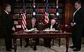 George W. Bush and John Howard signing a treaty inside the Commonwealth Parliament Offices.