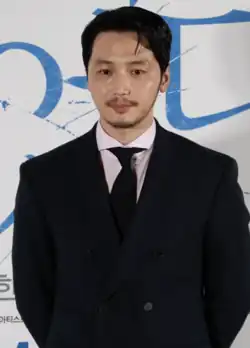 Byun wearing a black suit and looking at the camera during a press conference
