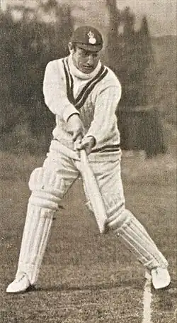 Black and white photograph of a male holding a cricket bat