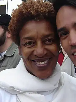 A woman in a white scarf, smiling