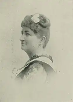 B&W portrait photo of a middle-aged woman with her hair in an up-do.