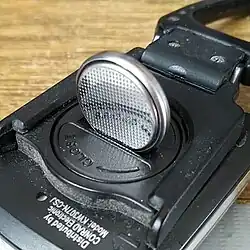 Coin slot-style screw head on a battery holder, capable of being opened using the CR2032 battery.
