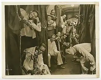 Cab Calloway and members of his band sit in a sleeper train car