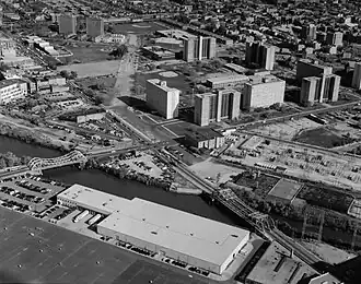 A black-and-white photograph of a neighborhood; it is taken from an aerial point of view.