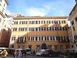 A four-story yellow apartment block in Rome