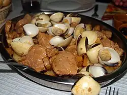 The main ingredients in carne de porco à alentejana are pork, clams and potatoes.