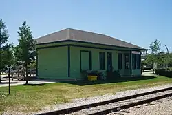 A small, wooden building painted green with a "CARROLLTON" sign