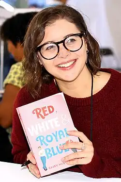 Casey McQuiston holding her book "Red, White & Royal Blue"