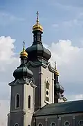 The building features three gilded towers, which represent the Trinity.