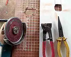 100&nbsp;mm (3.9&nbsp;in) angle grinder with diamond blade, with tiling snips being used to cut holes in tiles