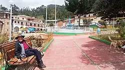 Man sitting at a bench in a plaza