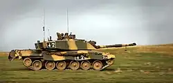 photo of a Challenger 2 tank at speed on grassy plain