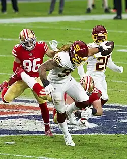 A man running with a football in the process of returning it for a touchdown.