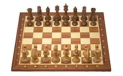 Staunton chess pieces arrayed on a chess board