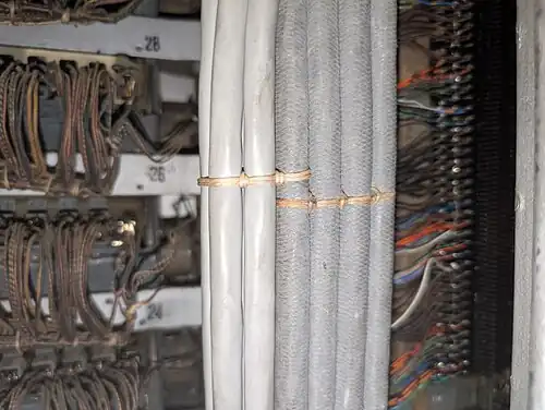 A Chicago stitch where some additional cables (grey plastic, left) have been added to an existing bundle (fabric cables, right).