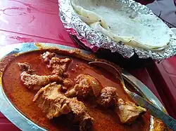 A chicken curry from Maharashtra, India with rice flour chapatis. The dish is popular worldwide.[40]