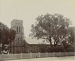 Photograph of a small church surrounded by trees