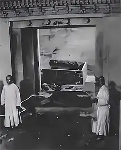 State of the burial chamber of the Empress Dowager Cixi's tomb, photographed as part of the post-1928 looting investigations. Her discarded corpse, burial shroud and damaged coffin are visible in the background.