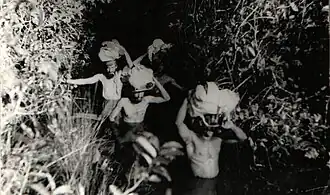 Three people are seen on the woods