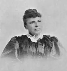 B&W portrait photo of a middle-aged woman with her hair in an up-do.